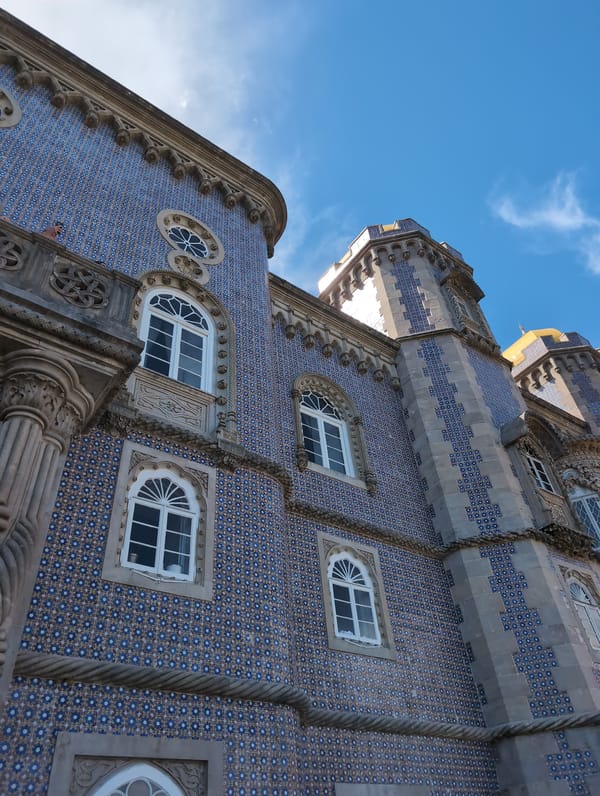 Tourist photographs Pena Palace's colorful architecture in Sintra