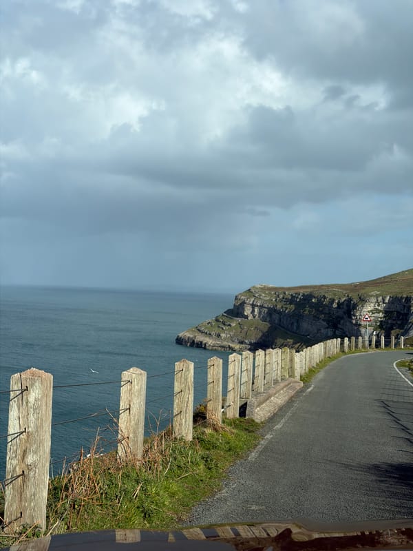 Coastal road with wooden fence observed in Llandudno