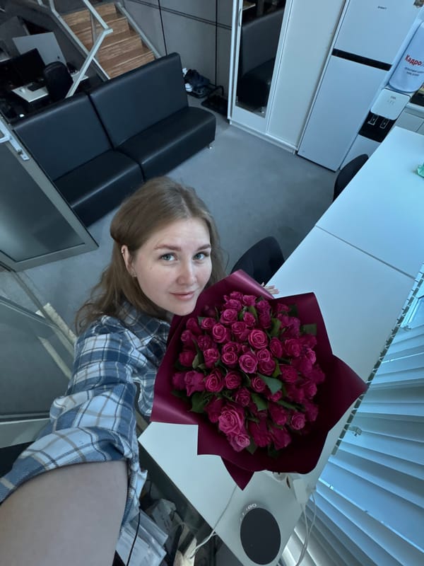 Woman takes rose bouquet selfies in Perm office