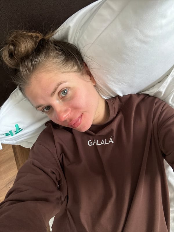 Woman rests on bed in brown sweatshirt, Gudauri Georgia