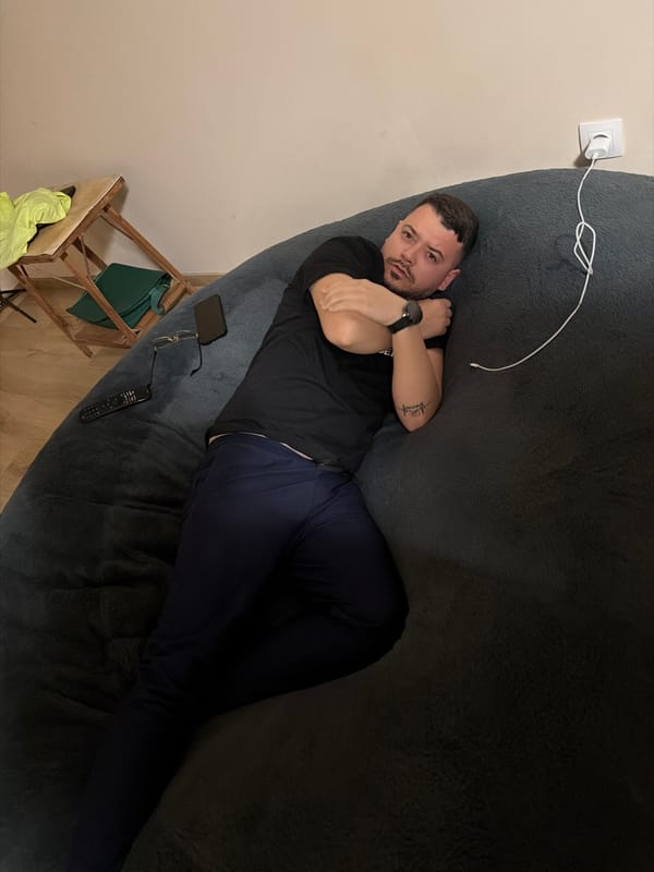 Man relaxing on beanbag chair with electronics nearby