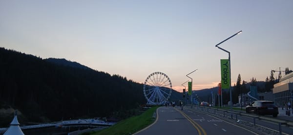 Mountain resort lights up at dusk with rides and market stalls