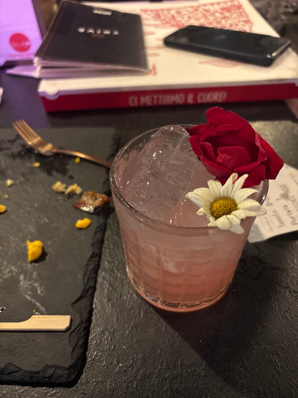 Floral-garnished cocktail documented in Milan evening dining scene