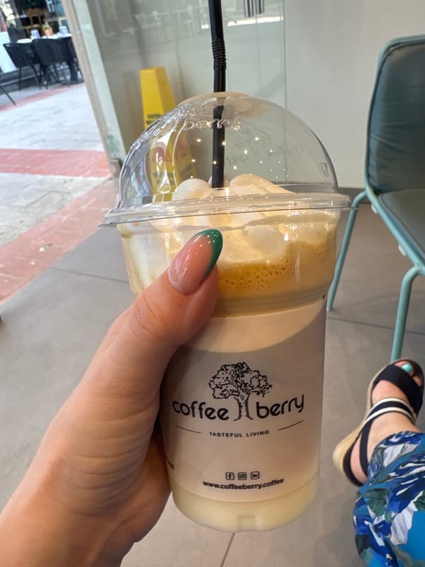 Person holds Coffeeberry branded coffee cup in Larnaca