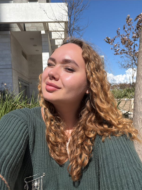 Woman poses amid modern architecture in Netanya street scene