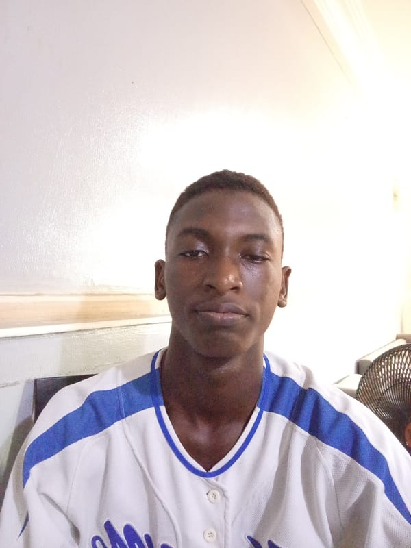Young man in baseball jersey photographed at location