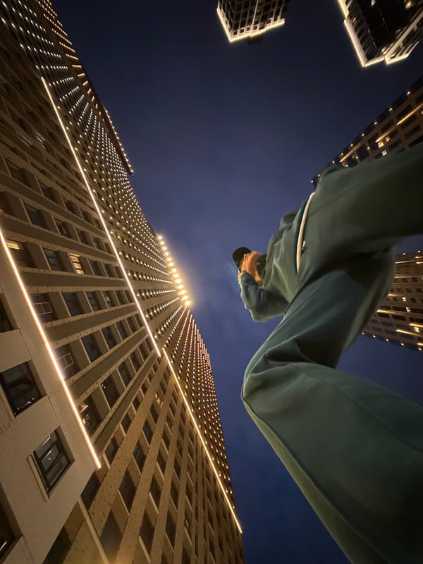 Teal tracksuit, phone in hand, looking up in Moscow