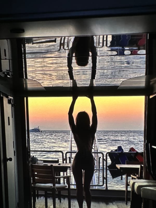 Sunset witnessed from ship at sea, woman silhouetted