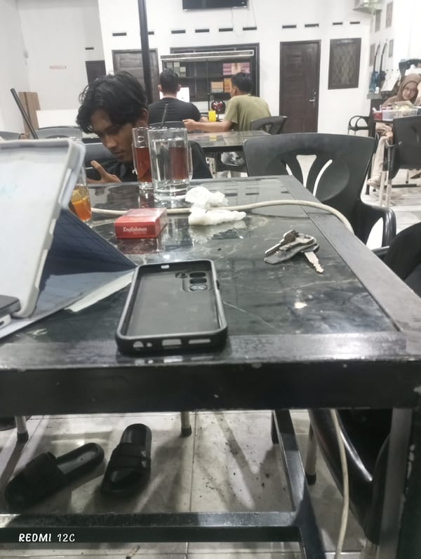 Young men use phones at Lhokseumawe cafe