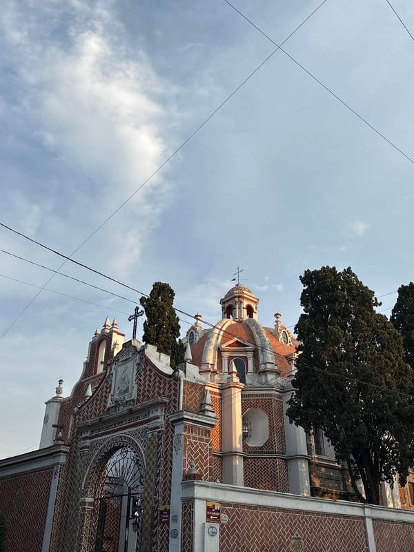 Domed brick church with cross photographed under gray sky