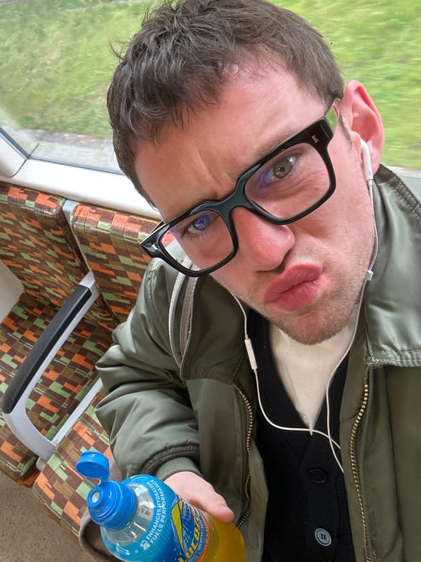 London train passenger drinks Lucozade during morning commute