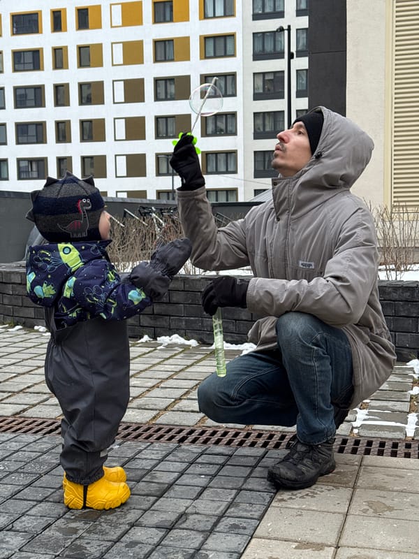 Father and child play with bubbles in Izhevsk courtyard