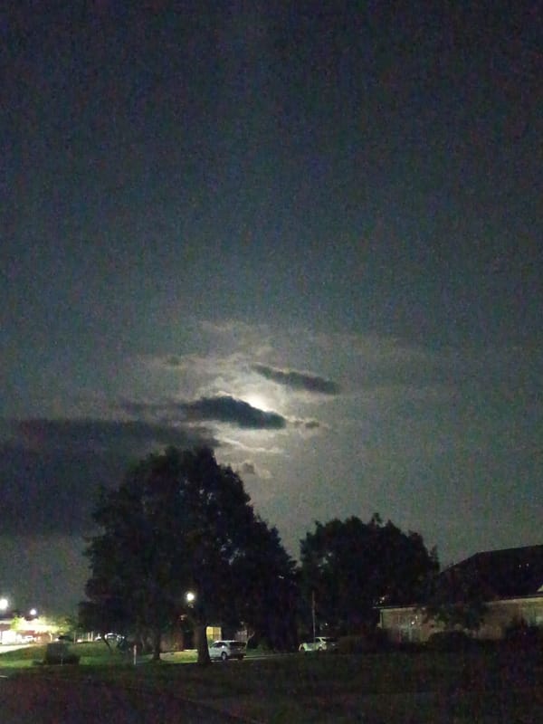 Moon and possible lightning share a cloudy Kentucky night sky