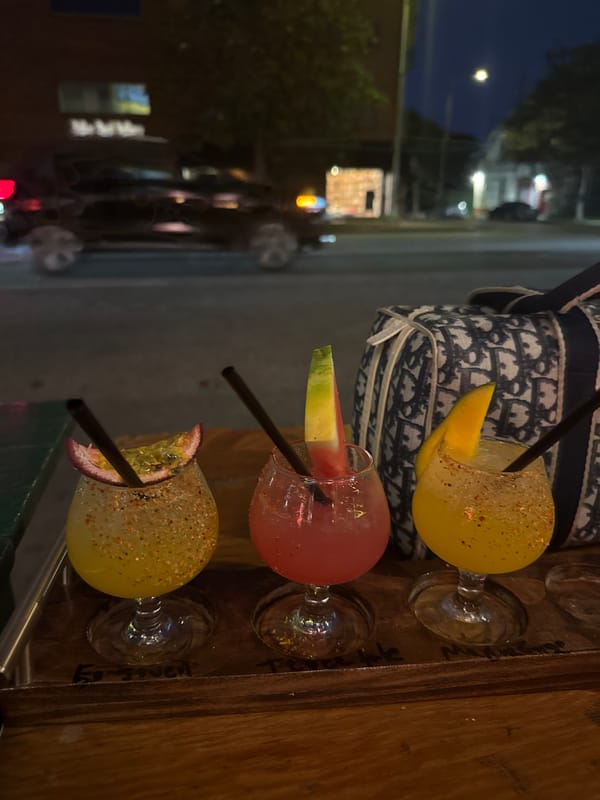 Three garnished cocktails spotted on wooden surface in Los Angeles