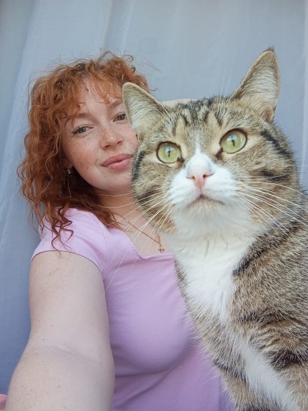 Woman poses with cat in early morning selfie