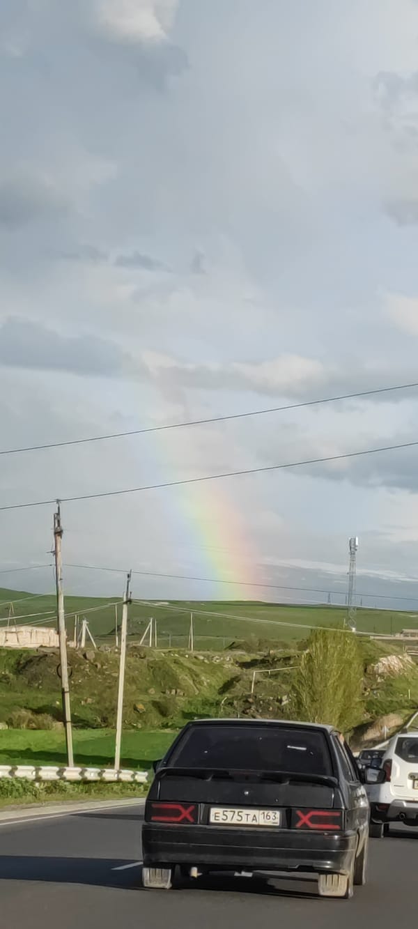 Rainbow appears over green hills near Azatan, Armenia