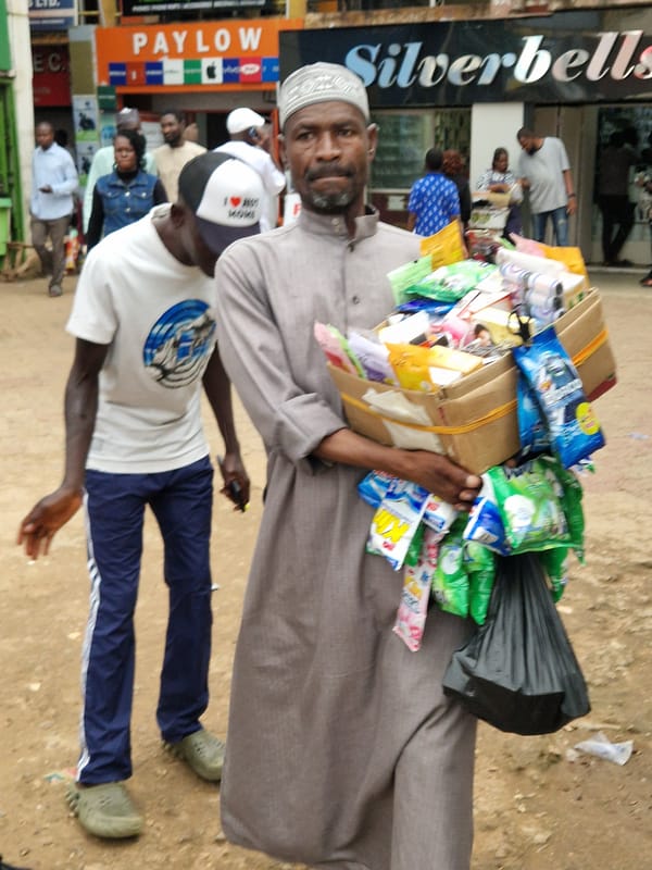 Street vendors moving goods through a bustling outdoor market