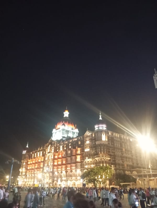 Evening crowds gather at illuminated Gateway of India, Mumbai