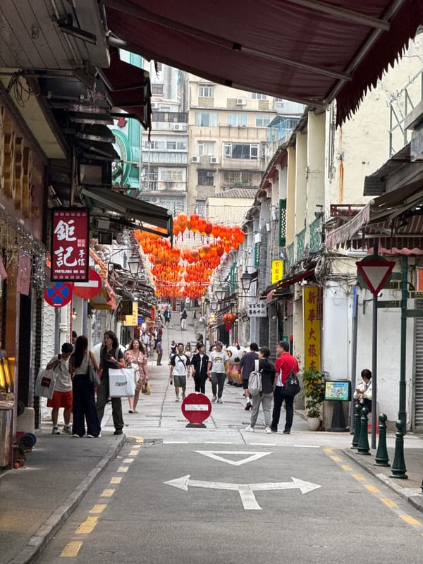 Morning crowds fill narrow Macau street amid mixed architecture