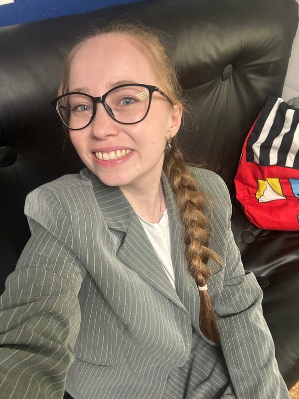 Woman in blazer photographed smiling in Saint Petersburg