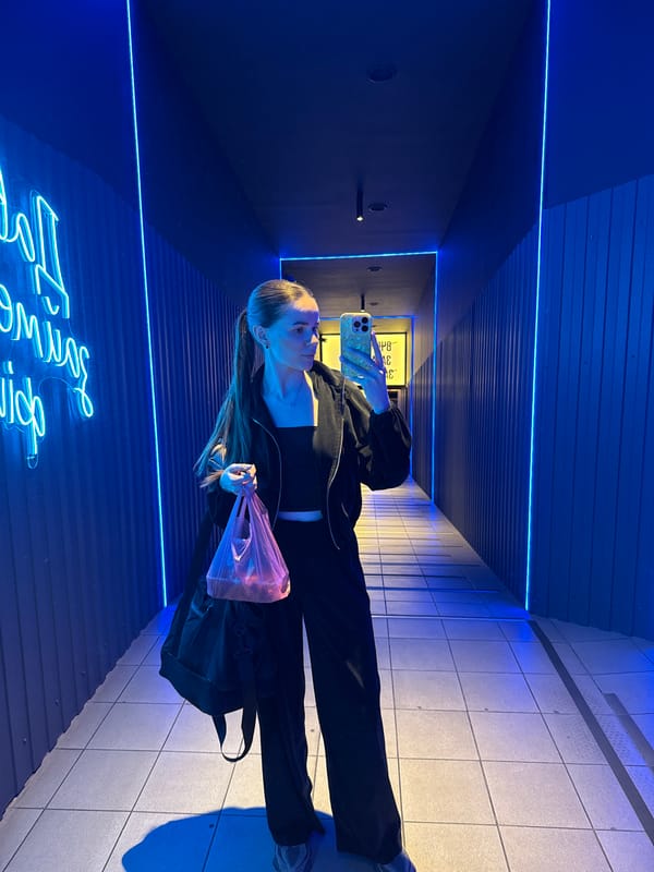 Mirror selfie in a neon-lit gym space, athletic outfit