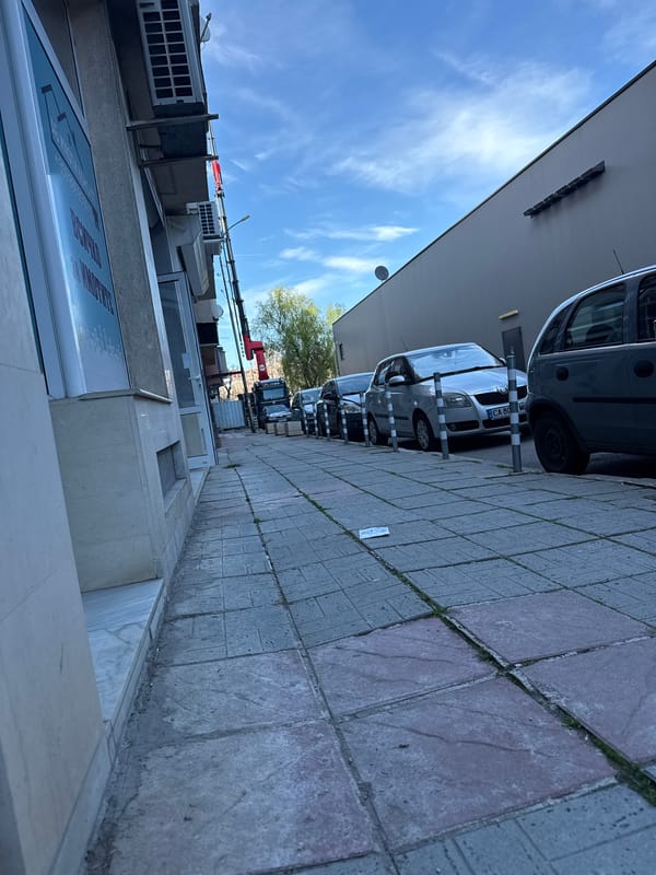 Urban street scene with parked cars, pedestrian documented simultaneously