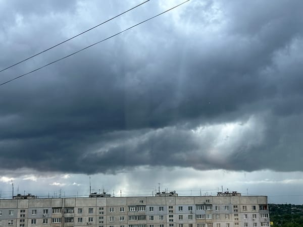 Storm clouds gather over urban area with street life