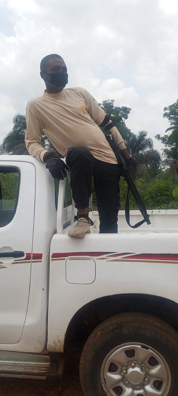 Men gather around pickup truck on rural Nigeria road