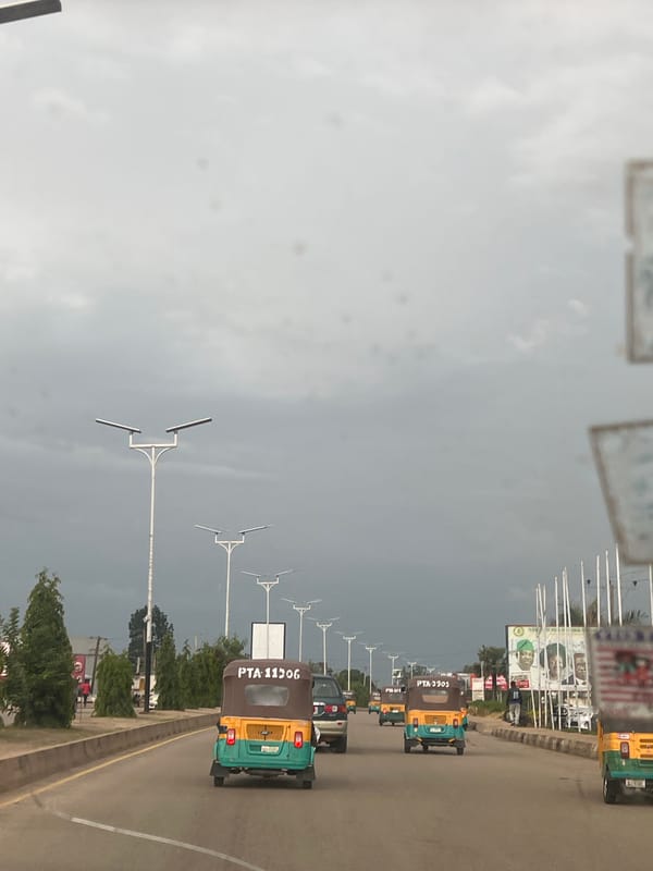 Street-level look at Jos roads, keke traffic, and infrastructure signage