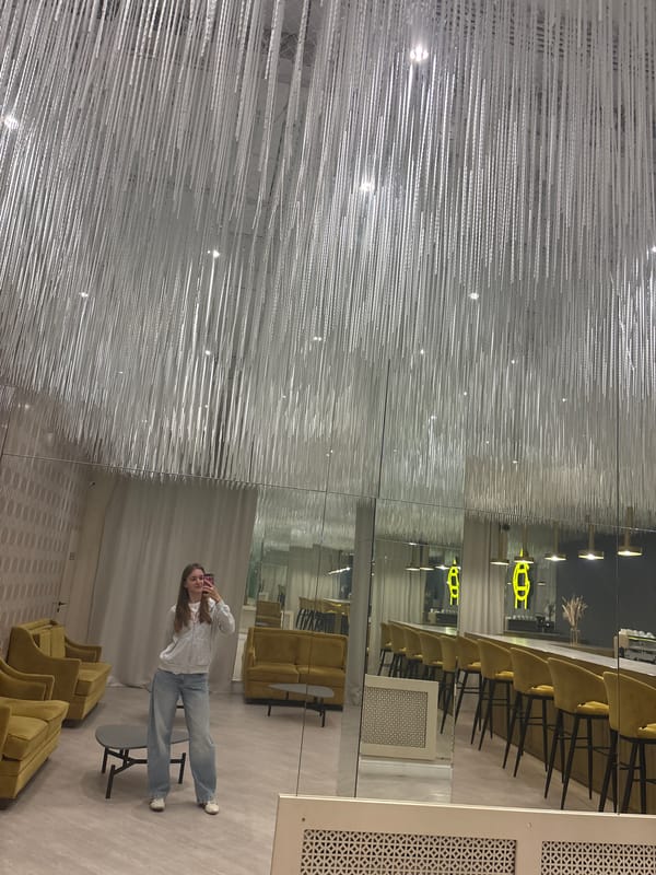 Woman takes mirror selfies in Perm showroom with artistic ceiling