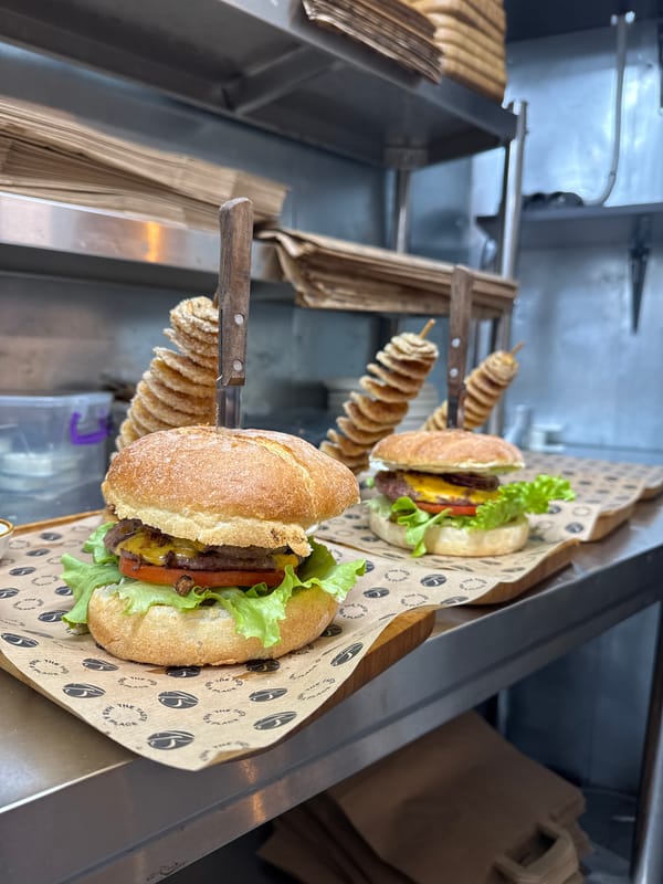 Food truck serves burgers and spiral potatoes on wooden trays