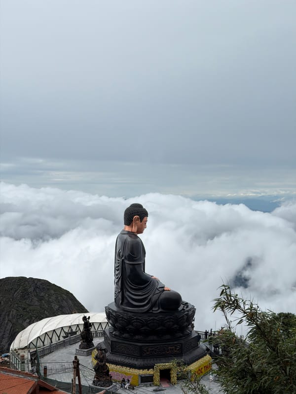 Buddha statue and mountain tower at a misty Vietnamese highland site