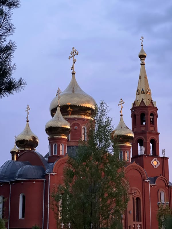 Golden-domed Orthodox churches photographed at dusk in Chaikovsky, Russia