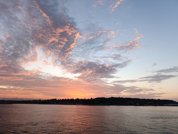 Sunset over Kiel Fjord with a silhouetted city skyline
