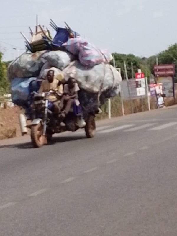 Loaded motorcycle with sidecar travels urban Tamale road