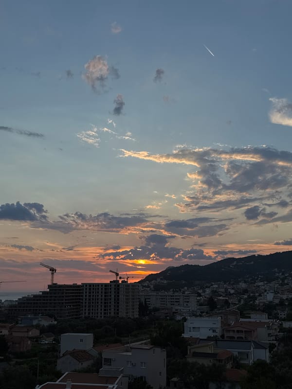 Sunset over Šušanj's coastline, mountains, and modern architecture