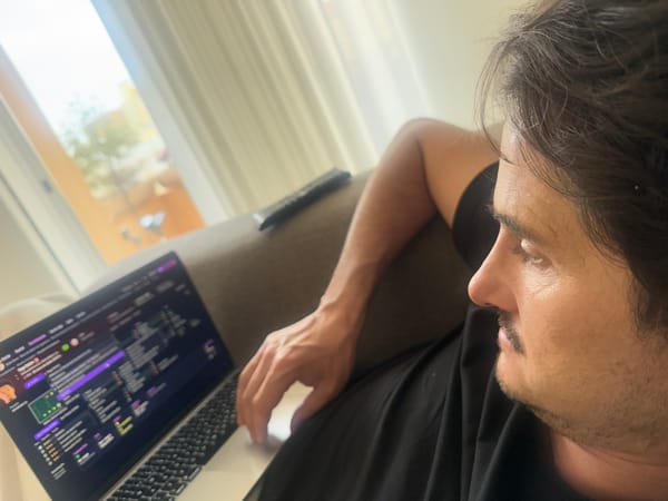 Man uses laptop on couch in Vila Nova de Gaia