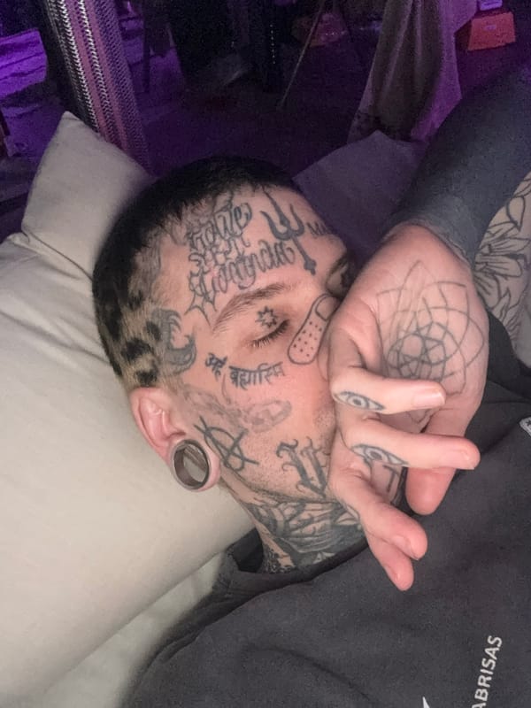Injured tattooed man rests indoors in Buenos Aires