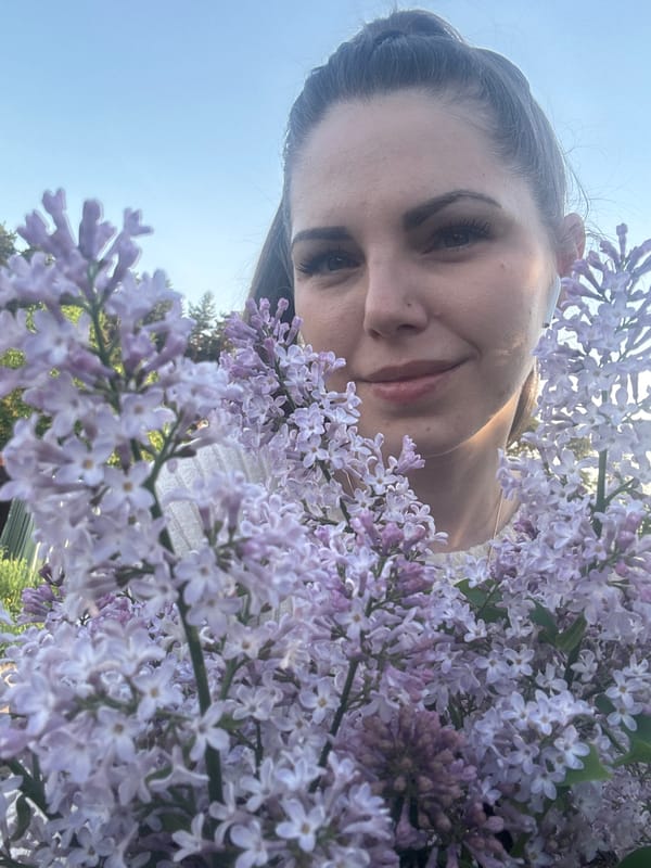 Woman poses with blooming lilacs in Раздолье, Russia