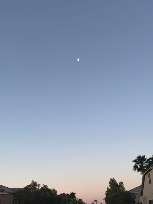 Crescent moon visible during daylight sky gradient in Las Vegas