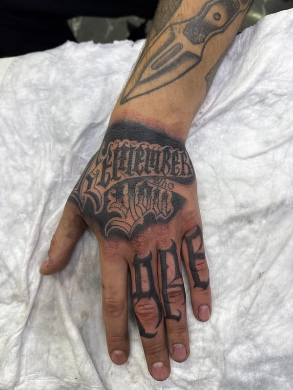 Heavily tattooed arm photographed resting on white fabric Moscow