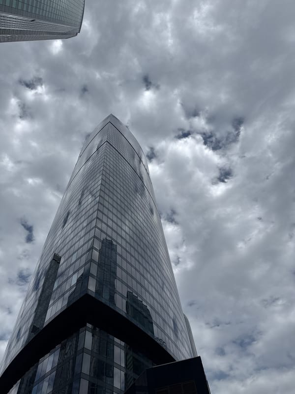Person photographed near modern skyscrapers in Khimki, delivery robot spotted