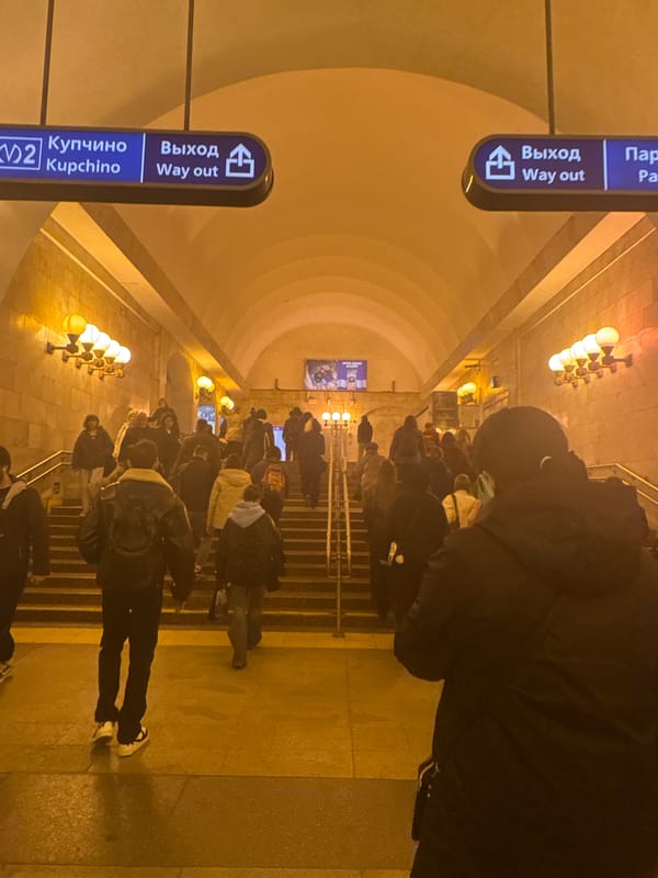 Evening commuters navigate Saint Petersburg metro station escalators