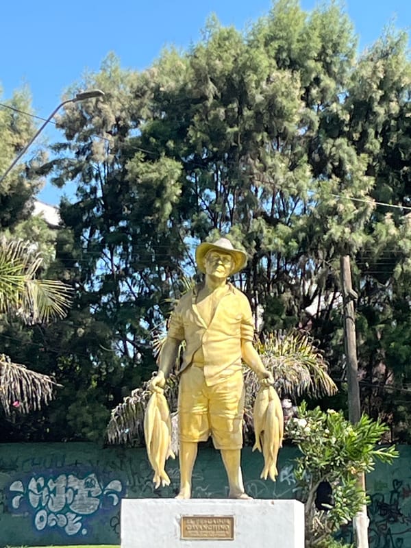 Golden fish-holding statue observed on green pedestal