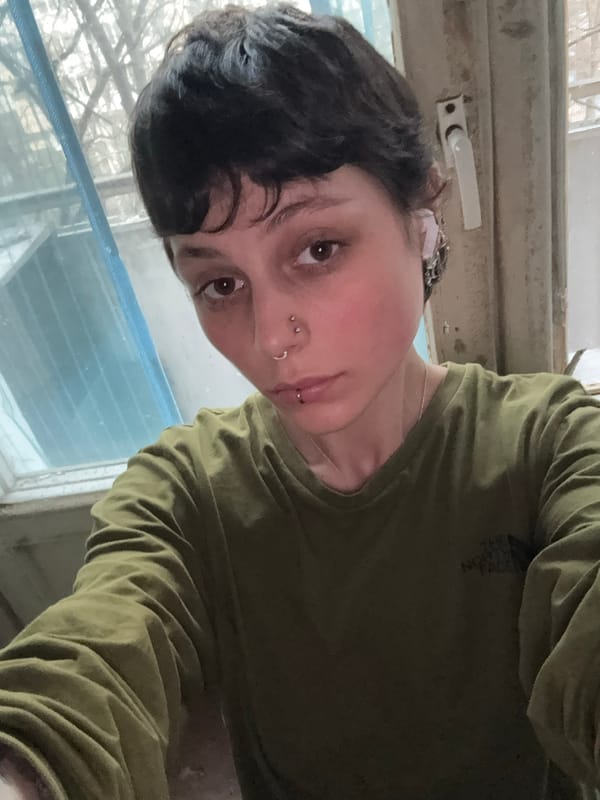 Person photographed by weathered window in Moscow indoor setting
