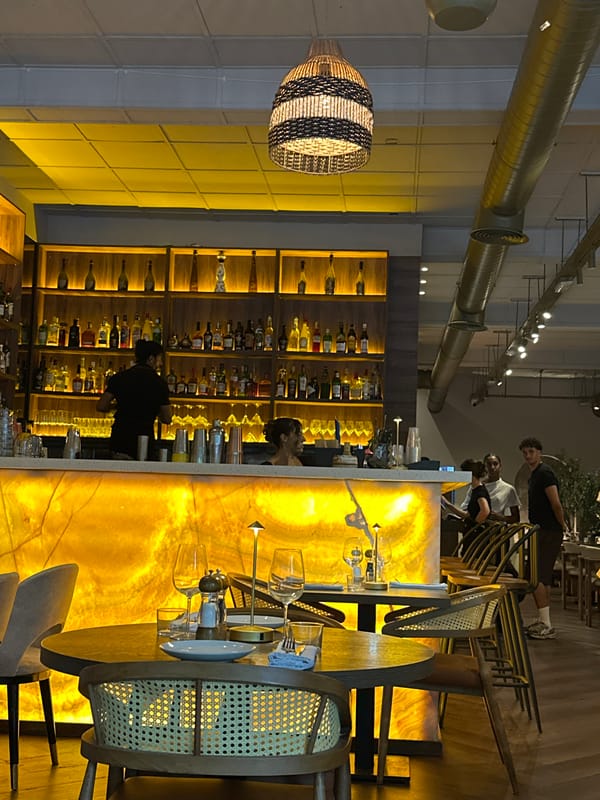 Evening at a bar, flowers in hand — looks like a celebration