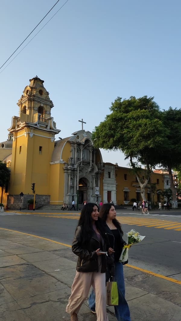 Two women photographed on Barranco sidewalk under clear skies