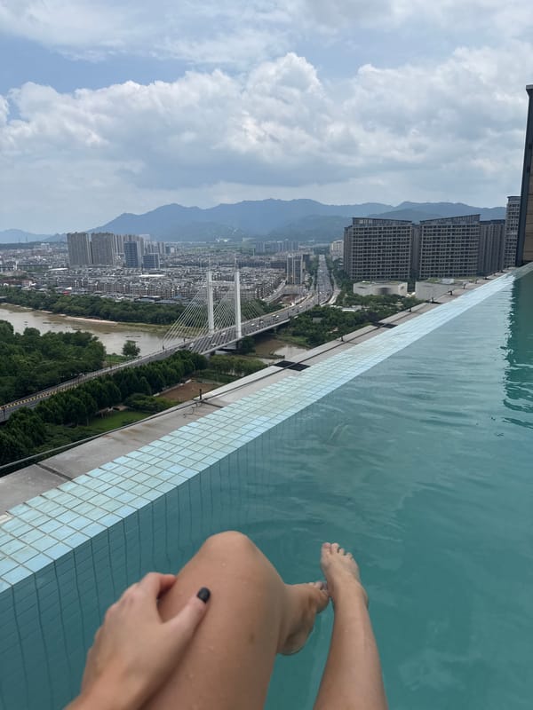 Rooftop pool day above Yiwu's skyline, mid-July
