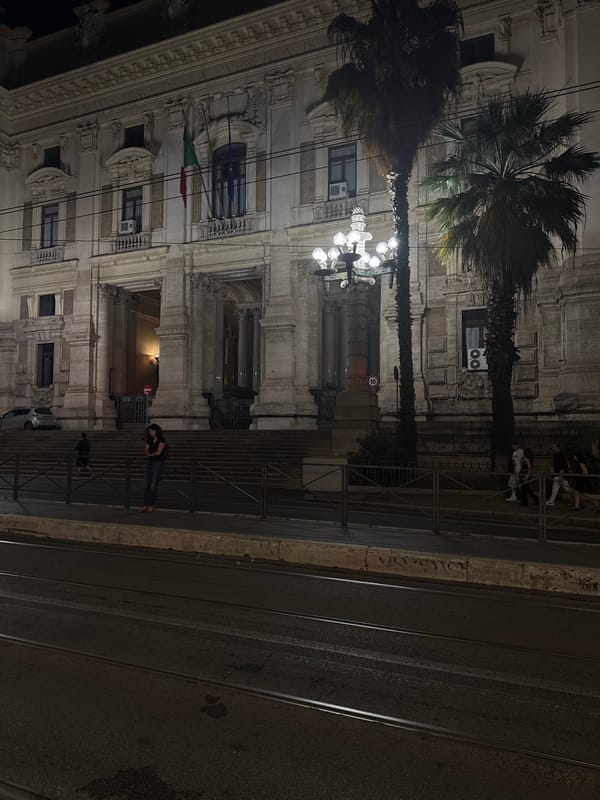 Classical Roman building with Italian flag photographed at night