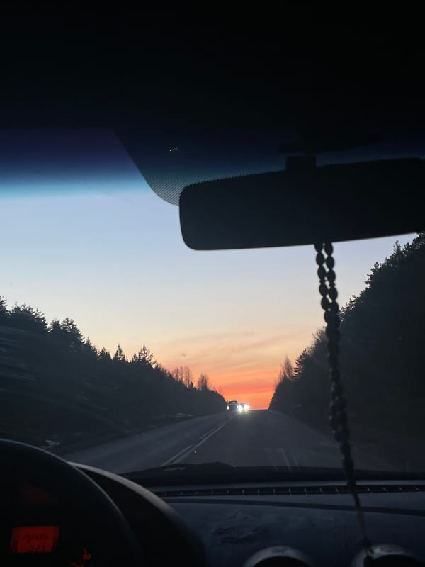 Driver captures sunset view during rural road journey